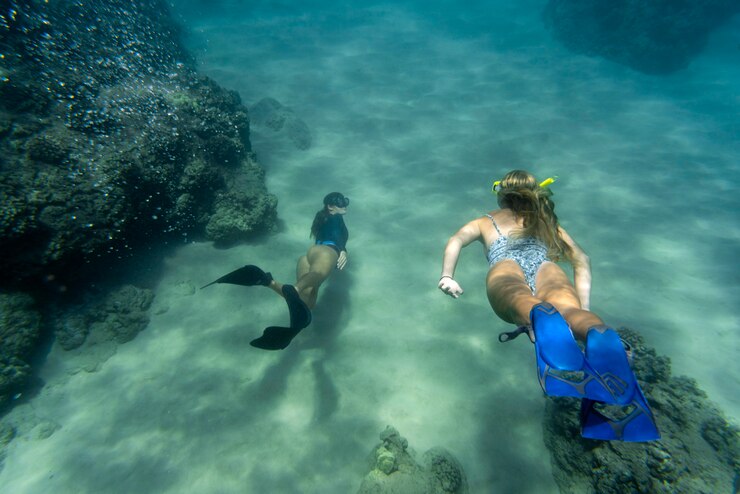 women-freediving-with-flippers-underwater_23-2148976499